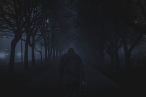 夜の森を歩く男性