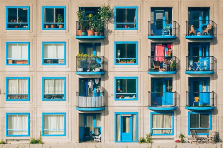 白いアパートの青い窓枠が綺麗に並ぶ